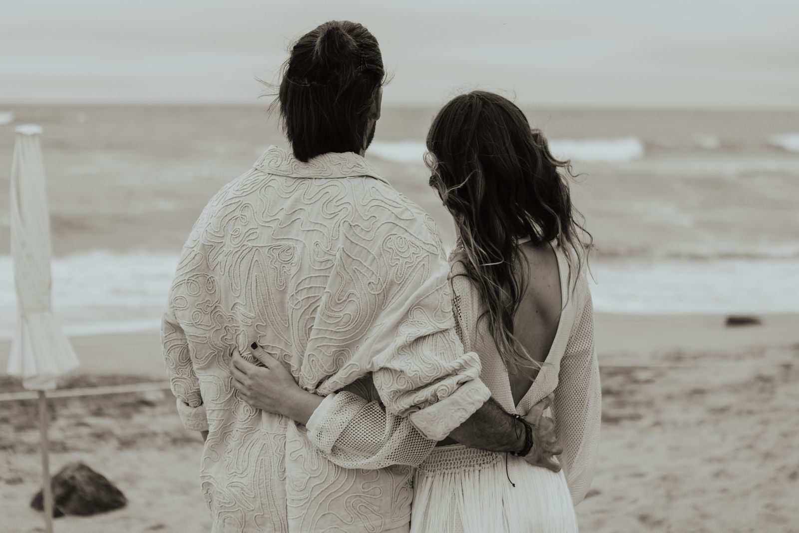 A couple with their arms around each other, backs to the camera