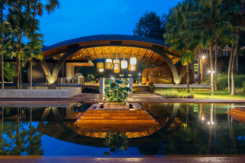 The resort at dusk, lit over a reflecting pool