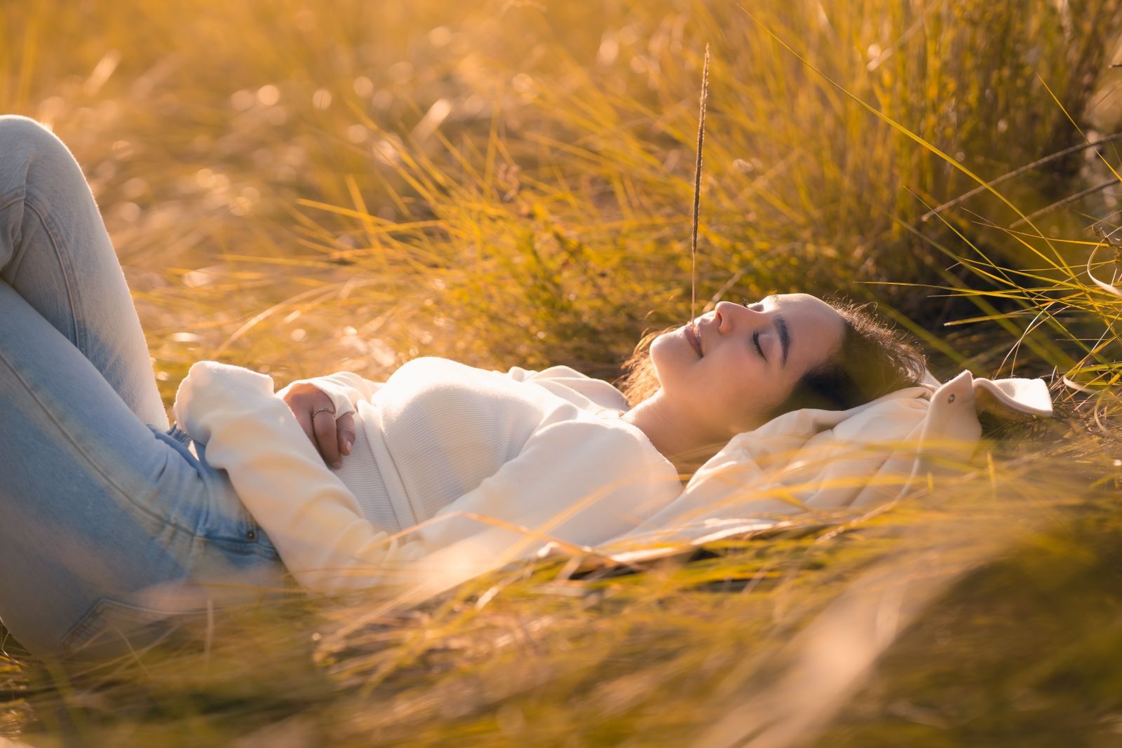 Lying back in golden grass, eyes closed
